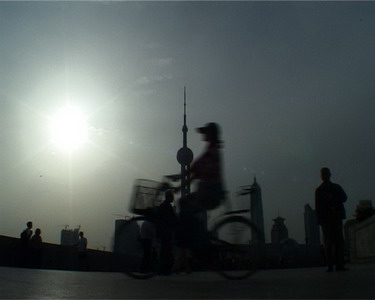 Sylvie showing to some characters how to bike in front of the camera, on the Bund